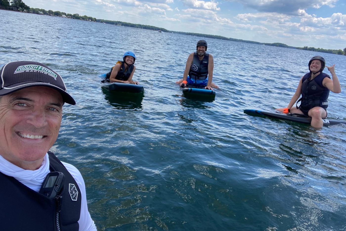 Dan taking a selfie with three riders floating on their eFoils on Lake Norman